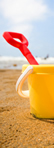 Sandy Beach image of a bucket and spade on a golden sandy beach